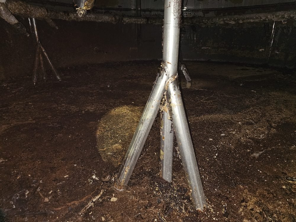 Interior of a process tank before cleaning, coated with brown residue and buildup