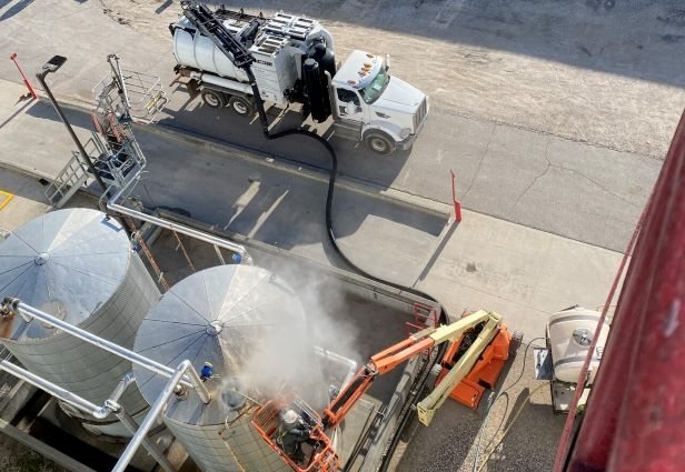 Enviro-Dyne crew hydroblasting process tanks at an ethanol plant from an aerial lift